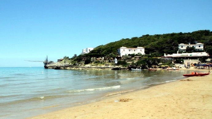 Baia di Manaccora a Peschici con spiaggia dorata, mare calmo e trabucco sul promontorio