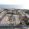 Vista aerea di un quartiere residenziale costiero con il mare sullo sfondo.