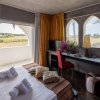 Stanza accogliente con letto, scrivania e grandi finestre ad arco. Vista campagna.