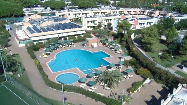 Piscina all'aperto circondata da lettini.