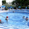 Piscina con persone che nuotano e ombrelloni.