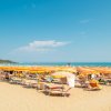 Spiaggia con ombrelloni gialli e arancioni.