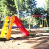 Parco giochi all'aperto con scivolo e altalena.