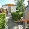 Bungalow circondato da verde, con barbecue in pietra.