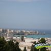 Vista panoramica di un paesino costiero con mare e faro.