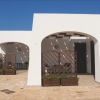 Spazi esterni di edifici con archi bianchi e divisori in legno.