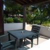Terrazza con tavolo e sedie di plastica, vista su giardino.