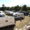 Camper parcheggiati in un'area di sosta con alberi.