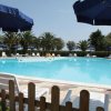 Piscina circondata da ombrelloni blu e lettini bianchi.
