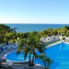Piscina con vista sul mare e vegetazione.
