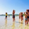 Persone fanno stretching in acqua bassa.