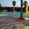 Piscina con sdraio e ombrelloni gialli.