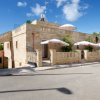 Edificio in pietra con terrazza e ombrelloni.