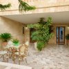 Cortile con sedie, tavolo e piante.